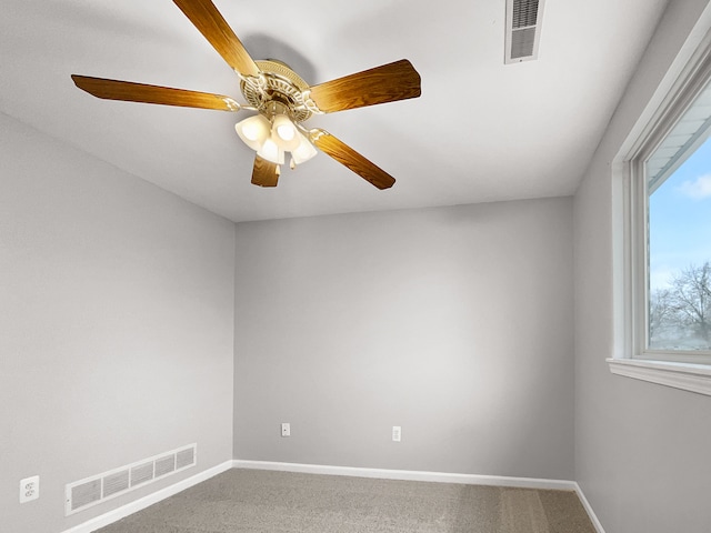 carpeted spare room featuring visible vents and baseboards