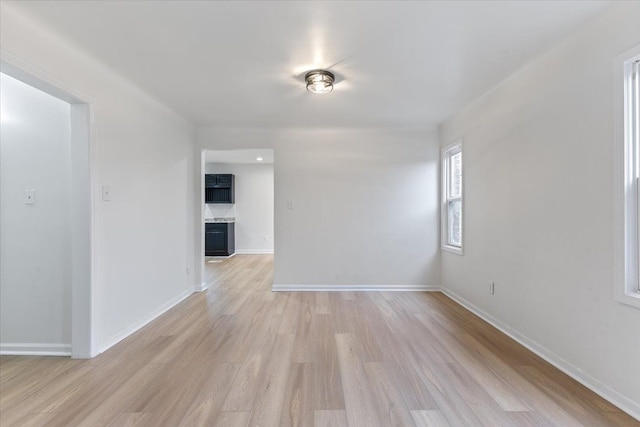 spare room with light wood finished floors and baseboards