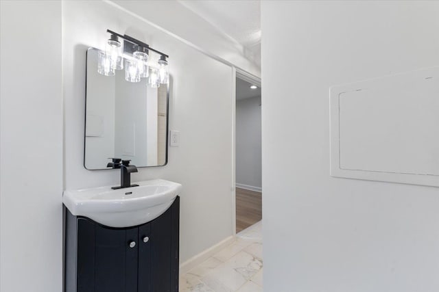 bathroom featuring marble finish floor, baseboards, and vanity