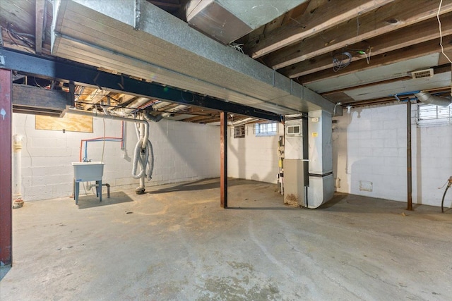 basement featuring a sink and heating unit