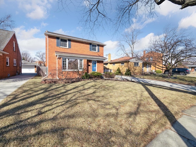 traditional-style home with brick siding, a front yard, and an outdoor structure