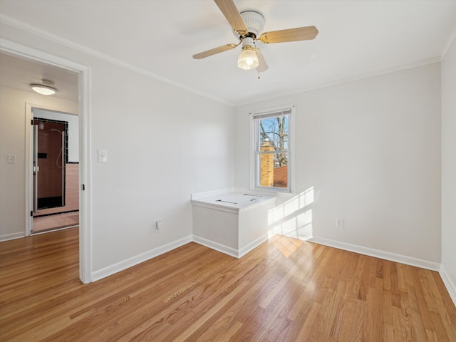 unfurnished room with light wood-type flooring, ceiling fan, baseboards, and ornamental molding