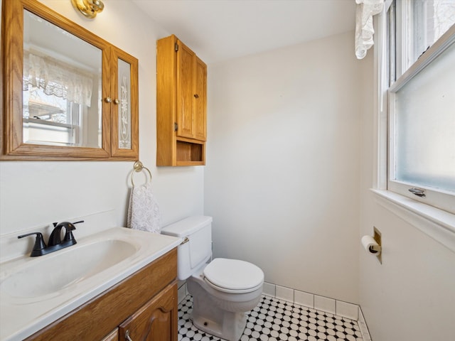 bathroom with baseboards, vanity, and toilet