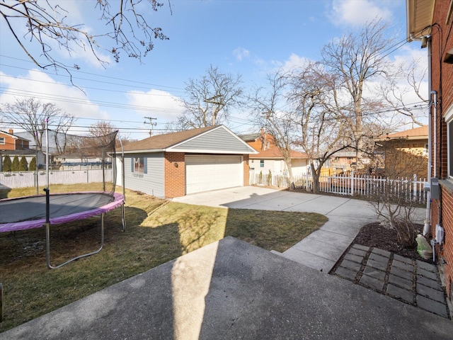 exterior space with a trampoline, an outbuilding, brick siding, and fence