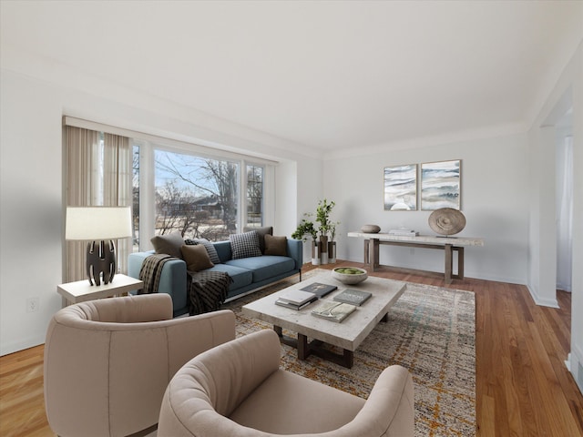 living area with baseboards and wood finished floors