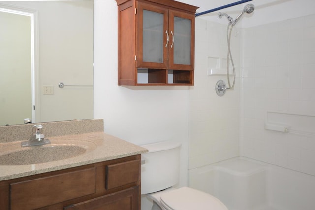 full bathroom featuring a shower, vanity, and toilet