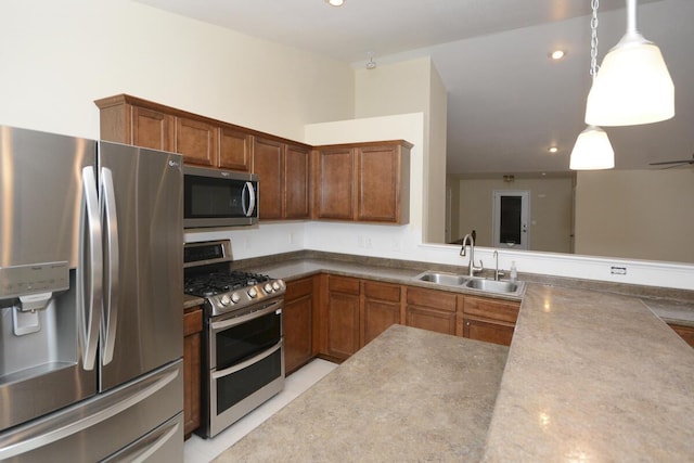 kitchen featuring brown cabinets, pendant lighting, stainless steel appliances, and a sink