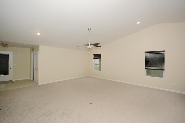 spare room with lofted ceiling, ceiling fan, light carpet, and baseboards