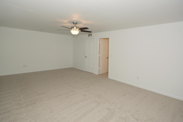 spare room with baseboards, visible vents, ceiling fan, and light colored carpet