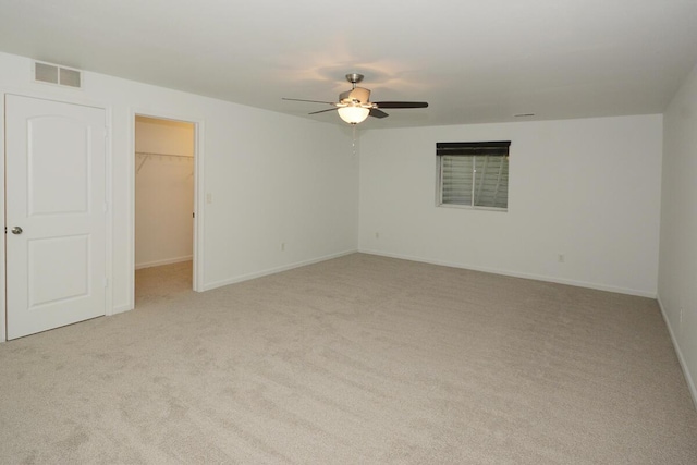 empty room with light carpet, baseboards, visible vents, and a ceiling fan