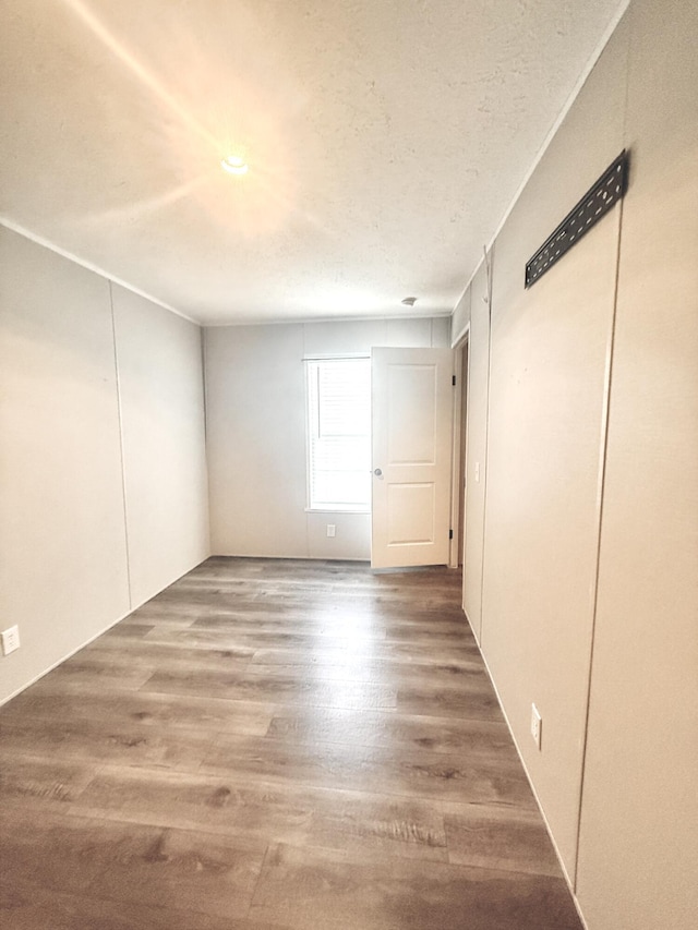 empty room featuring a textured ceiling and wood finished floors