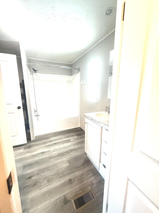 full bath with a shower, visible vents, ornamental molding, vanity, and wood finished floors