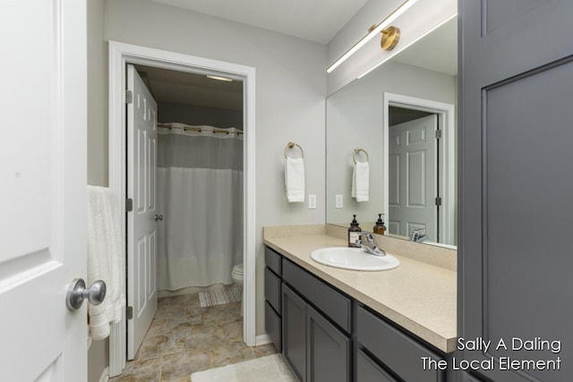 bathroom featuring curtained shower, vanity, and toilet