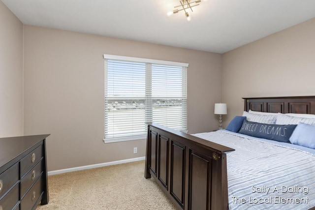 bedroom with light carpet and baseboards