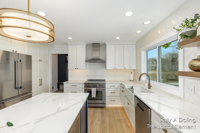 kitchen with premium appliances, open shelves, a sink, white cabinetry, and wall chimney exhaust hood