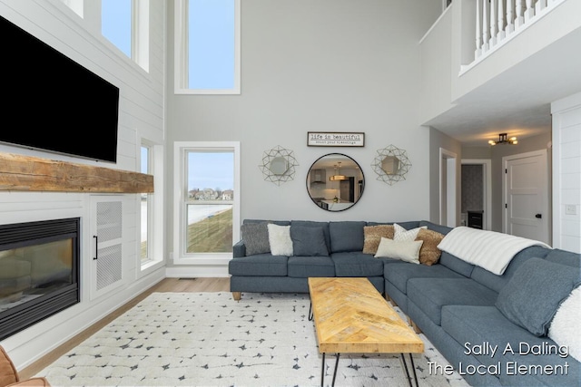 living area with wood finished floors and a glass covered fireplace