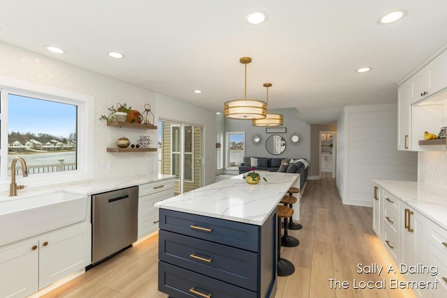 kitchen with white cabinets, light wood-style flooring, stainless steel dishwasher, open shelves, and a sink