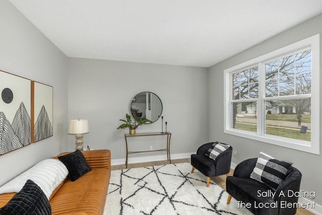 living area featuring baseboards and wood finished floors