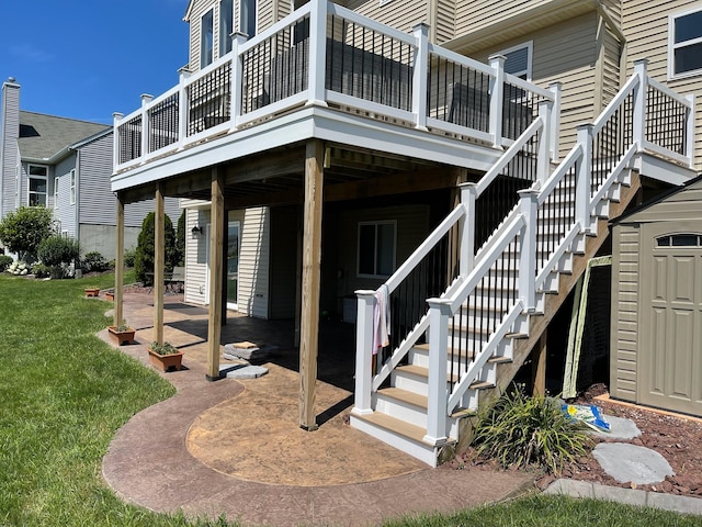 entrance to property featuring a lawn, a patio area, and a wooden deck