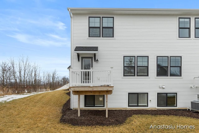 back of house with central AC and a yard