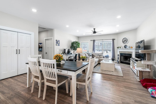 dining room with a fireplace, visible vents, wood finished floors, and recessed lighting