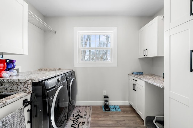 clothes washing area featuring washer and clothes dryer, wood finished floors, cabinet space, and baseboards