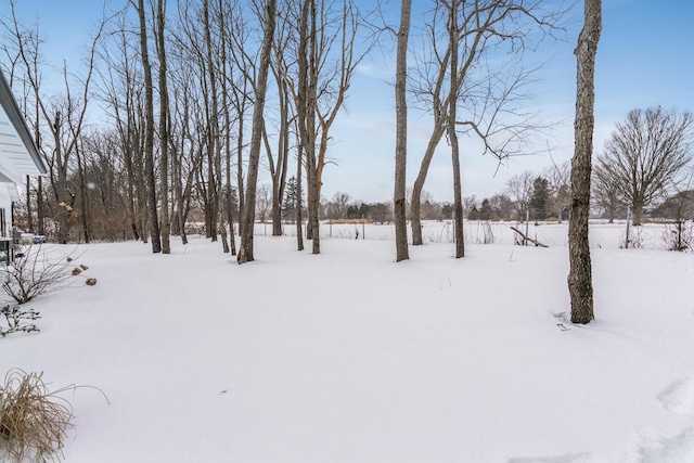 snowy yard featuring fence