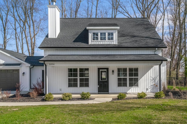 modern inspired farmhouse featuring roof with shingles, a chimney, covered porch, a garage, and a front yard