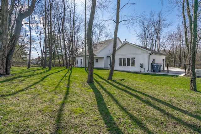 rear view of property with fence and a lawn
