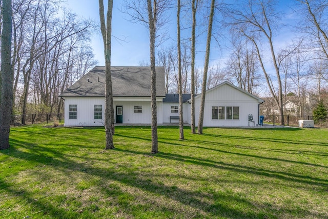 back of property with a yard and fence