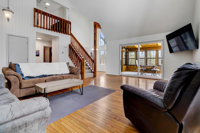 living room featuring hardwood / wood-style flooring, stairway, and high vaulted ceiling