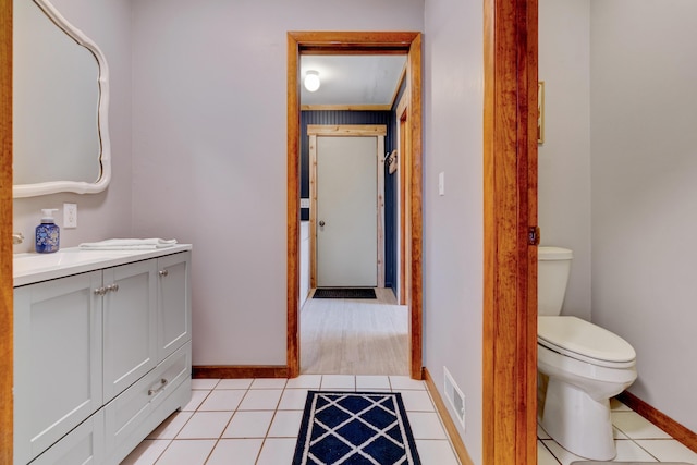 bathroom with visible vents, baseboards, toilet, tile patterned flooring, and vanity