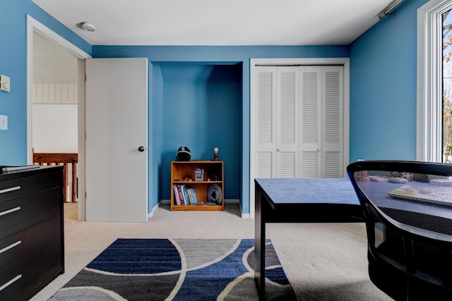 carpeted home office featuring baseboards