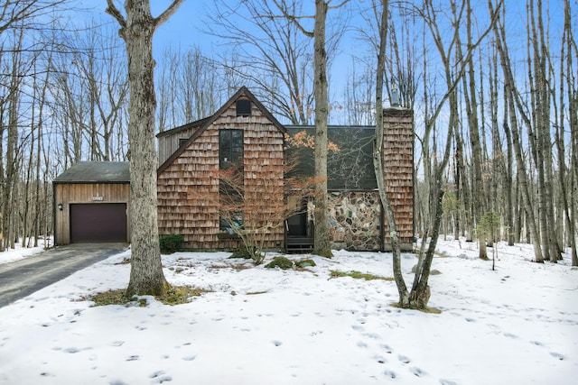 snow covered property featuring an attached garage