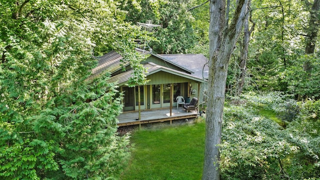 exterior space featuring a shingled roof, french doors, a yard, and a deck