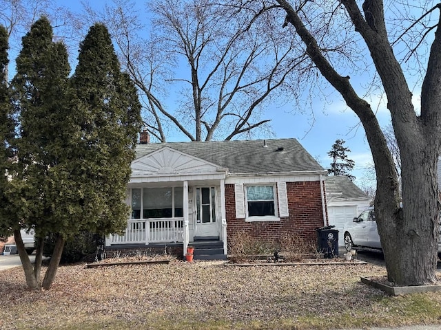 view of front of home featuring a garage, covered porch, a chimney, and brick siding