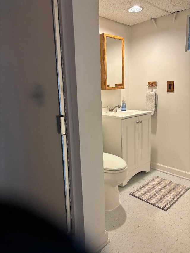 bathroom featuring toilet, baseboards, and vanity