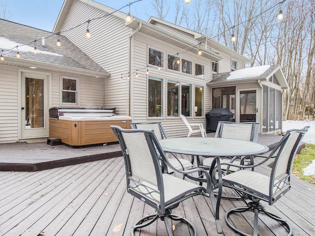 wooden deck with outdoor dining space, a sunroom, a grill, and a hot tub