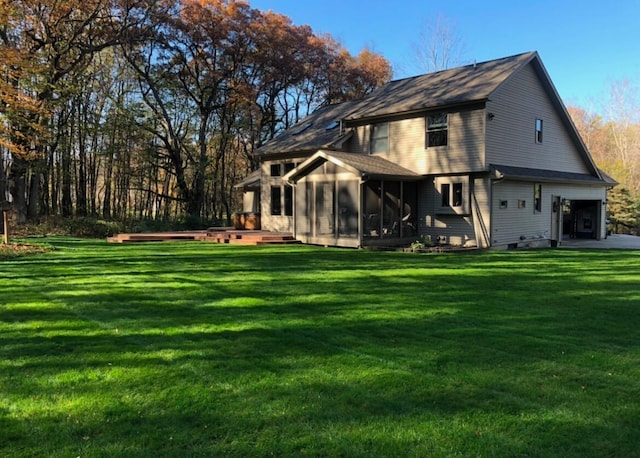 view of side of home with a deck, a yard, a sunroom, and a hot tub