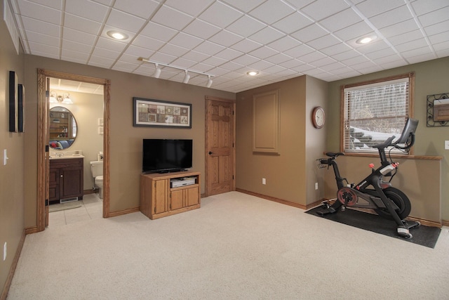 workout area featuring baseboards, a drop ceiling, track lighting, and light colored carpet