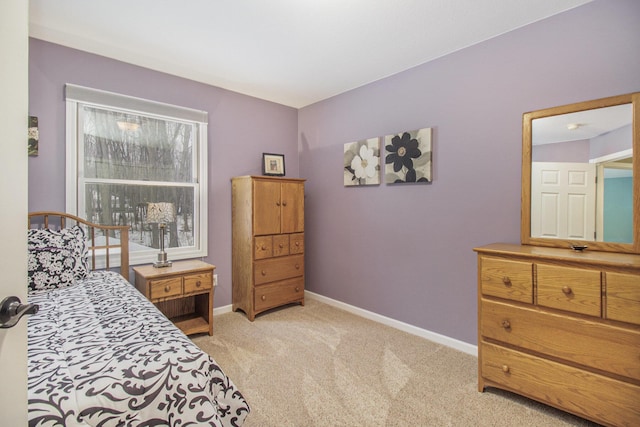 bedroom featuring baseboards and light colored carpet