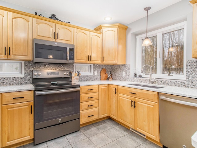 kitchen featuring stainless steel appliances, light brown cabinetry, a sink, and light countertops