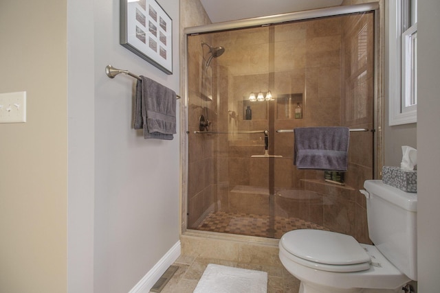 full bath with toilet, a shower stall, visible vents, and baseboards