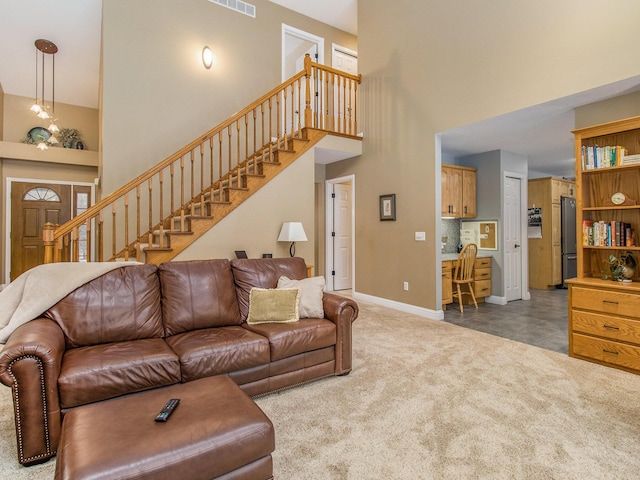 living area featuring stairs, carpet floors, a high ceiling, and baseboards