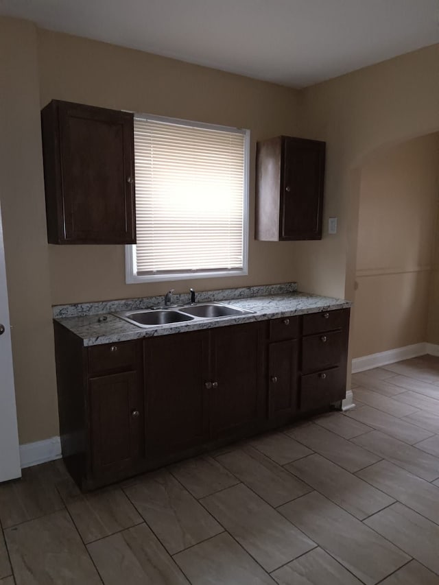 9183 Bishop St, Detroit, MI 48224 - kitchen featuring a sink, light countertops, baseboards, and dark brown cabinets
