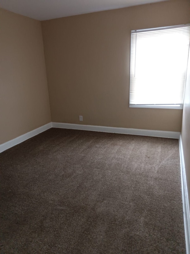 9183 Bishop St, Detroit, MI 48224 - empty room with baseboards and dark colored carpet