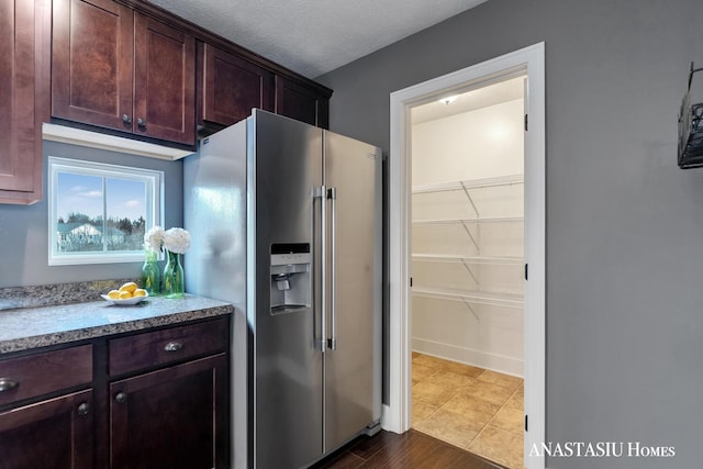 kitchen with high end fridge, a textured ceiling, and dark brown cabinets