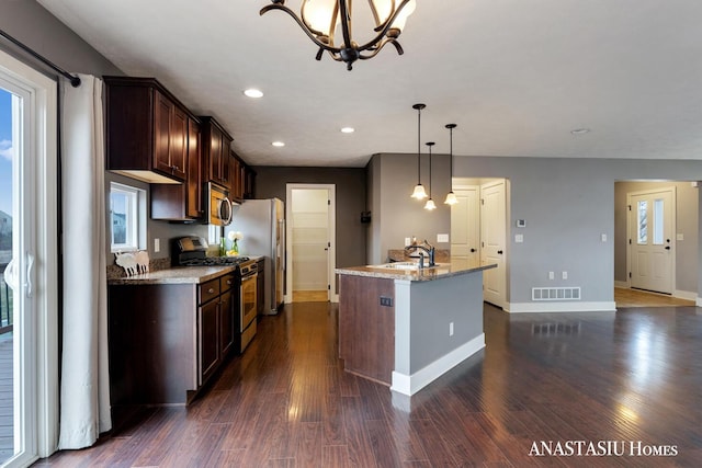 kitchen featuring a chandelier, light stone counters, dark wood-type flooring, visible vents, and appliances with stainless steel finishes