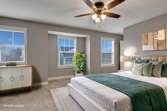 bedroom with baseboards, a ceiling fan, and light colored carpet