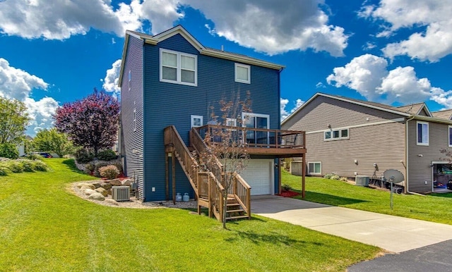 rear view of house with concrete driveway, a lawn, an attached garage, cooling unit, and stairs